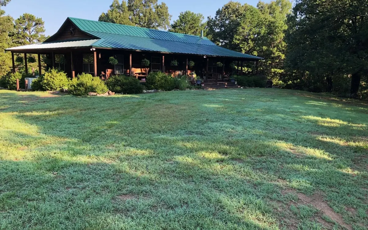 A thick, healthy green lawn spread out in front of an Arkansas home